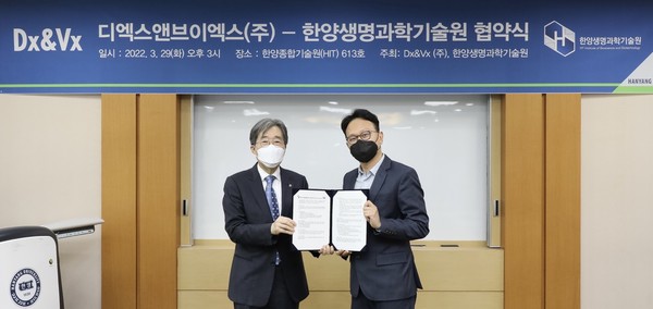 Dx&Vx CEO Park Sang-tae (left) and Hanyang Institute of Bioscience and Biotechnology President Bae Sang-cheol hold up the cooperation agreement at the institute in Seongdong-gu, Seoul, on Tuesday.