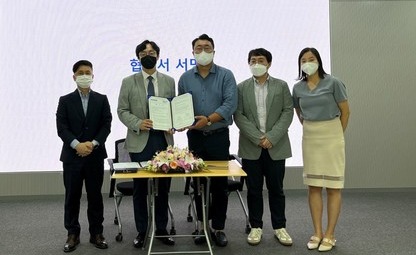 Huinno CEO Gil Yeong-joon (center) shows the signed agreement during a ceremony at the Seoul National University Hospital on Thursday.