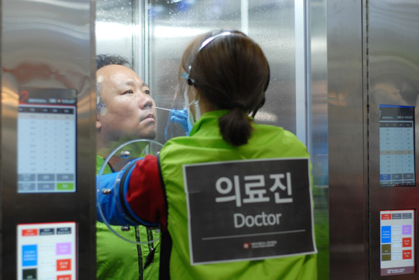 An employee of H Plus Yangji Hospital demonstrates the walkthrough negative pressure booth.