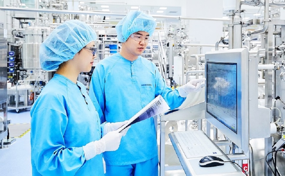 Samsung Biologics employees check the drug manufacturing process on a screen at the company’s plant. (Samsung Biologics)