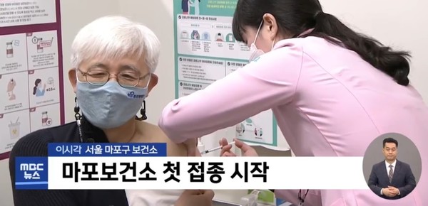 Kim Yun-tae, director of the Purme Foundation Nexon Children's Rehabilitation Hospital, gets AstraZeneca's Covid-19 vaccine at a public health center in Mapo-gu, Seoul, on Friday. President Moon Jae-in and KDCA Commissioner Jeong Eun-kyeong also visited the nation’s first vaccine rollout site. (Screen capture from MBC)