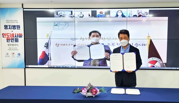 Myongji Hospital Chairman Lee Wang-jun (right) signed an agreement with Korean Association in Indonesia President Park Jae-han (on-screen) to provide healthcare services, including Covid-19 treatment, for Koreans living in Indonesia on Wednesday.