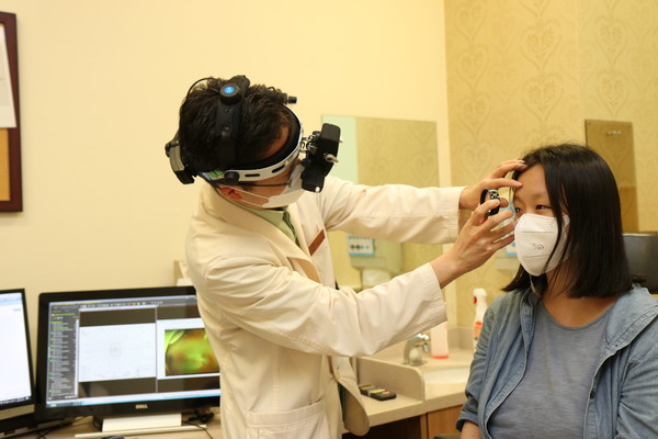 Professor Kim Sang-jin (left) of the Department of Opthalmology at Samsung Medical Center diagnoses a female patient in her 20s with inherited retinal degeneration at the hospital.