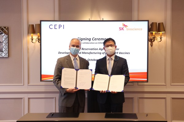 SK Bioscience CEO Ahn Jae-yong (right) and CEPI CEO Richard Hatchett hold up the extended cooperation contract at Brussels, Belgium, on Tuesday.