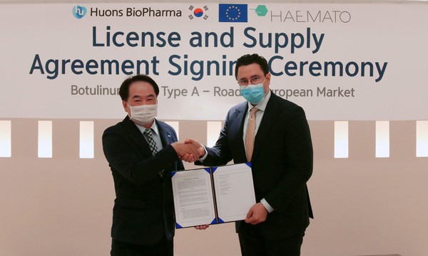 Huons Biopharma CEO Kim Young-mok (left) and Haemato Pharm CEO Patrick Brenske shake hands after signing the cooperative agreement at Huons Biopharma headquarters in Pangyo, Gyeonggi Province, on Monday.