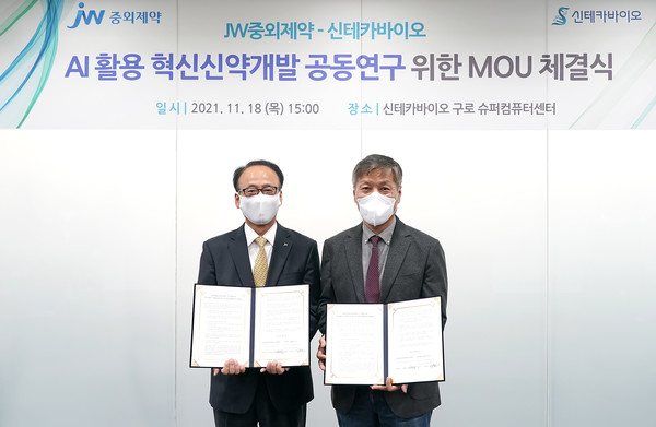 JW Pharmaceutical CEO Lee Sung-yeol (left) and Syntekabio CEO Jung Jong-sun hold the cooperation agreement at Syntekabio's Guro Supercom Center in Guro-gu, southwestern Seoul, on Thursday.