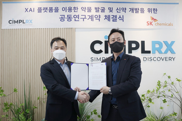 SK Chemicals R&D Center Director Kim Jeong-hoon (right) and Cimplrx CEO Cho Seong-jin shake hands after signing the cooperation agreement at Cimplrx headquarters in Songpa-gu, southeastern Seoul, on Monday.