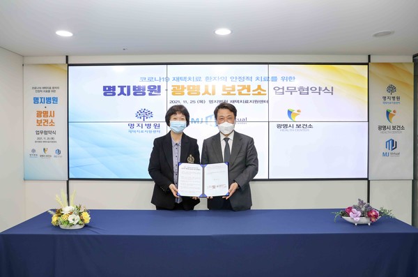 Myongji Hospital Chairman Lee Wang-jun (right) and Gwangmyeong City Public Health Center Director Lee Hyun-sook hold up their cooperation agreement at the hospital in Goyang, Gyeonggi Province, last Thursday.