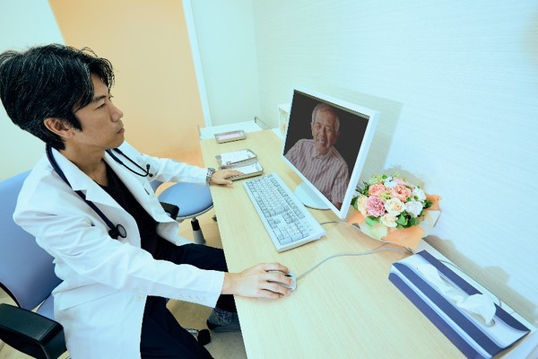 A doctor at a general hospital provides remote medical care for a senior patient.