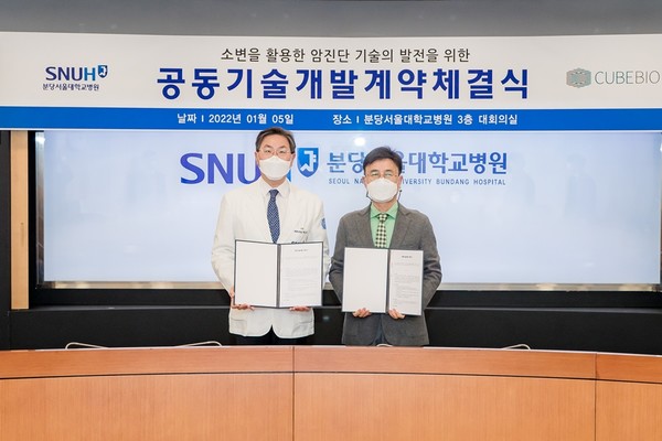 SNUBH President and CEO Paik Nam-jong (right) and Cube Bio Vice President Kim Jung-gon hold up their cooperation agreement at the hospital in Bundang, Gyeonggi Province, on Wednesday
