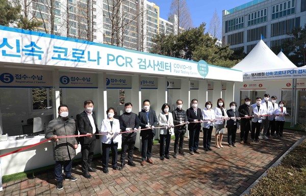 Myongji Hospital Chairman Lee Wang-jun (fifth from right) and other hospital workers and guests cut a ribbon to dedicate the rapid Covid-19 polymerase chain reaction (PCR) test center at the hospital in Goyang Gyeonggi Province on Wednesday.