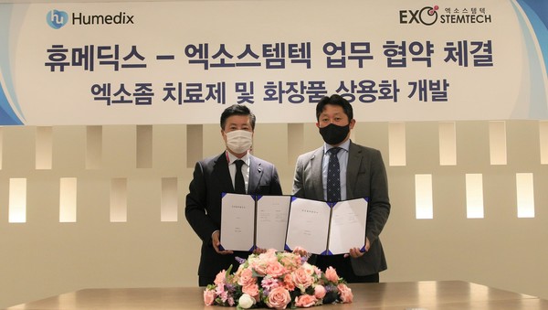 Humedix CEO Kim Jin-hwan (left) and Exostemtech CEO Cho Yong-woo hold up the cooperation agreement at Humedix in Gyeonggi Province.