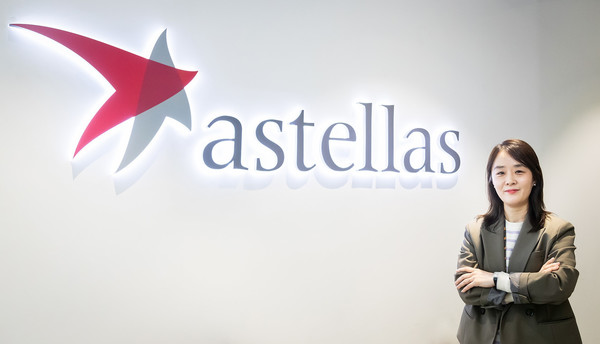 Kim Jin-hee, director of Astellas Korea’s Oncology Business Unit, stands beside her company’s logo after an interview with Korea Biomedical Review.