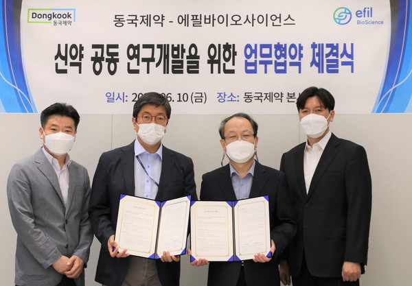 Dongkook Pharmaceutical CEO Song Joon-ho (second from left) and Efil Bioscience CEO Kim Jung-hoon hold a cooperative agreement to develop new drugs at Dongkook Pharmaceutical headquarters in Gangnam-gu, Seoul, last Friday.