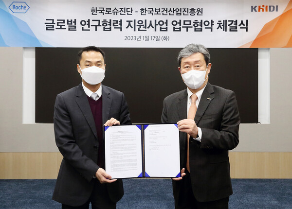 Roche Diagnostics Korea general manager Kit Tang (left) and KHIDI President Cha Soon-do hold up their cooperative agreement at Roche Diagnostics Korea headquarters in Gangnam-gu, Seoul, Tuesday.