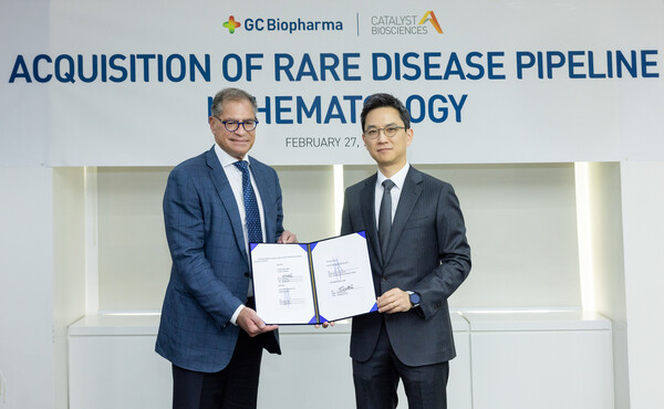 GC Biopharma President Huh Eun-chul (right) and Catalyst Biosciences CEO Nassim Usman hold up the asset purchase agreement at GC headquarters in Yongin, Gyeonggi Province, Monday.