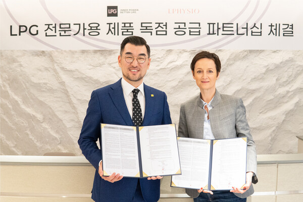 LPG Group's Asia Export Manager Sylvie Champagne Blanc (right) and LPHYSIO CEO Lee Yoon-jae hold up the exclusive supply agreement at LPHYSIO headquarters in Gangnam-gu, Seoul, Thursday.