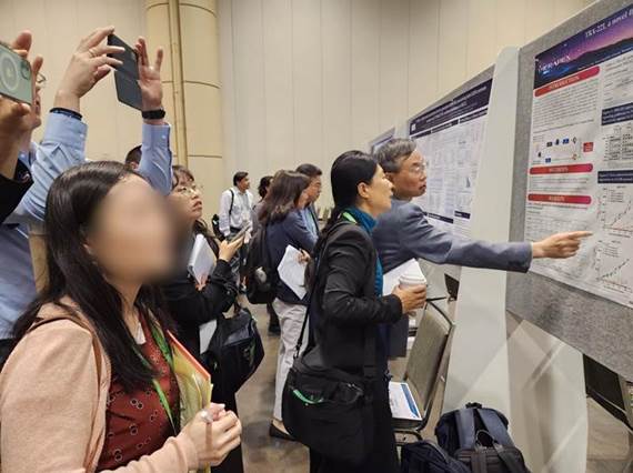 Participants stand in front of Therapex's poster study on TRX-221 during the AACR 2023 conference held at Orange Country Convention Center in Orlando, FL., Tuesday. (Courtesy of Therapex)