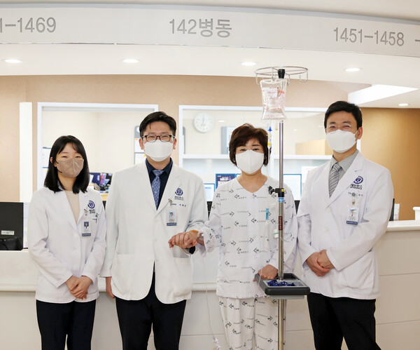 Professor Lee Jae-geun (second from left) and the polycystic liver disease patient Kim Ok-hee (second from right) pose for a photo with the medical team after receiving the final test of the transplanted liver's function.