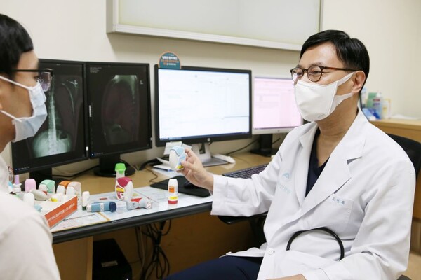 Professor Oh Yeon-mok of the Pulmonology Department at Asan Medical Center in Seoul treats an asthma patient. (Courtesy of Asan Medical Center)