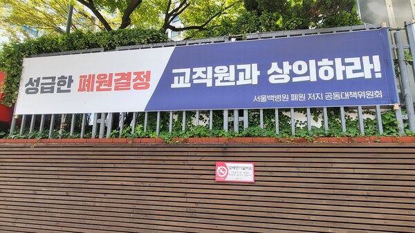 On the wall outside Seoul Paik Hospital, a banner posted by the Joint Task Force to Stop the Closure of Seoul Baek Hospital read, “We condemn the unilateral, helter-skelter administration of the foundation headquarters.”
