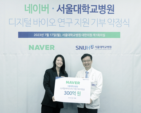 Naver CEO Choi Soo-yeon (left) and SNUH President Kim Young-tae show the signed agreement between the two organizations. (Credit: SNUH)