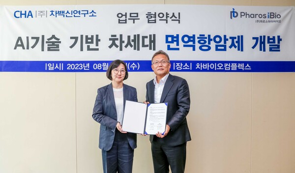 Cha Vaccine Institute CEO Yum Jung-Sun (left) and Pharos iBio CEO Yoon Jeong-hyuk hold up the cooperation agreement at CHA Bio Complex in Pangyo, Gyeonggi Province, Wednesday.