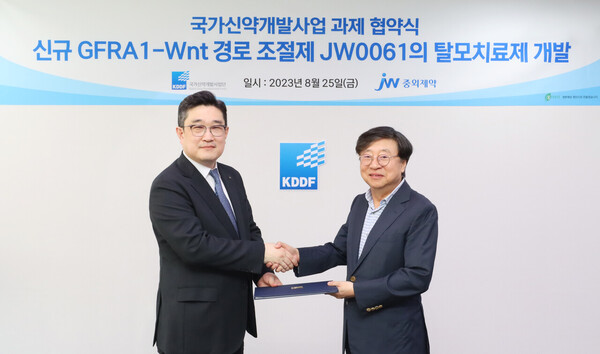 JW Group CTO Park Chan-hee (left) and Muk Hyeon-sang, head of the Korea Drug Development Fund (KDDF), signed a research and development agreement for the company’s Wnt-targeted hair loss treatment JW0061 at the KPX Building in Mapo-gu, Seoul, last Friday.