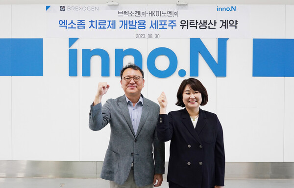 HK inno.N Bio Research Center Executive Director Won Sung-yong (left) and Brexogen CEO Kim Sue pose for a photo after signing the contract manufacturing agreement at HK inno.N Bio Research Center in Hanam, Gyeonggi Province, Wednesday.