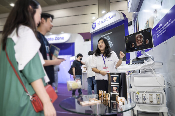 A GE HealthCare employee explains how its 3D ultrasonic device works to a married couple expecting a child at the BeFE Baby Fair 2023 held in COEX from Sep. 14 to 17.