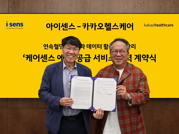 Kakao Healthcare CEO Hwang Hee (right) and i-SENS CEO Nam Hak-hyun hold up the cooperation agreement at Kakao Healthcare headquarters in Seongnam, Gyeonggi Province.