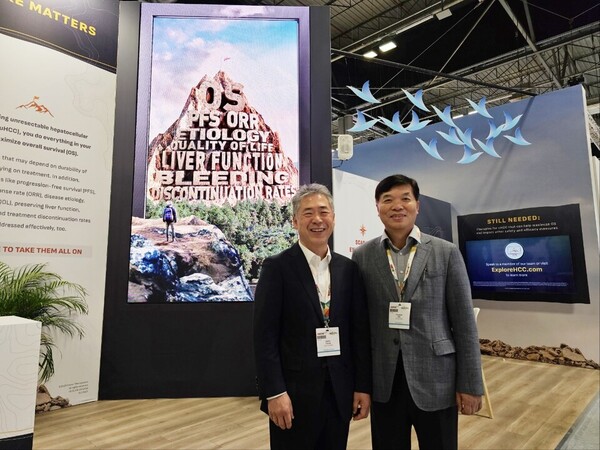 Elevar Therapeutics CEO Chong Sae-ho Jung (left) and HLB Group CTO Han Yong-hae stand in front of Elevar’s booth at the European Society for Medical Oncology Annual Meeting (ESMO 2023) in Madrid on Friday. (KBR photo)