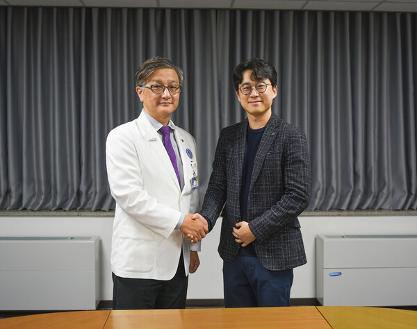 AUMC Director of Planning and Coordination Office Professor Lim Sang-hyun (left) and Kakao Brain CEO Kim Il-doo shake hands after signing the cooperation agreement at Ajou University Hospital in Suwon, Gyeonggi Province, last Thursday. (credit: AUMC)