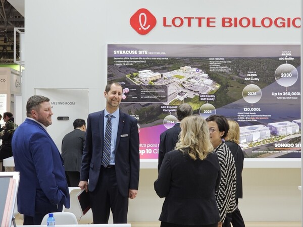 Michael Houseladen (center), president of Lotte Biologics USA, welcomes visitors at the company’s booth during the CPHI 2023 event. (KBR photo)
