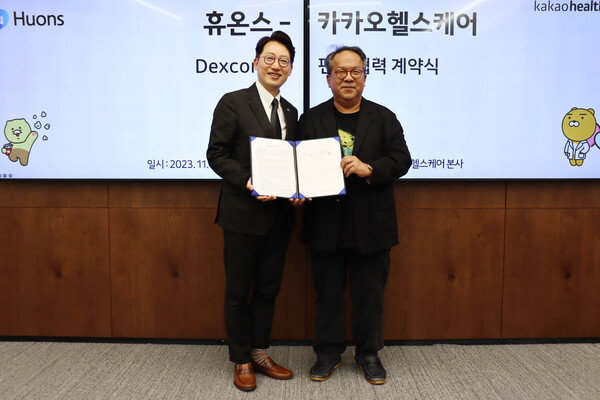 Huons CEO Yoon Sang-be (left) and Kakao Healthcare CEO Hwang Hee hold up the co-marketing agreement at Kakao Healthcare headquarters in Pangyo, Gyeonggi Province, last Friday. (Credit: Huons)