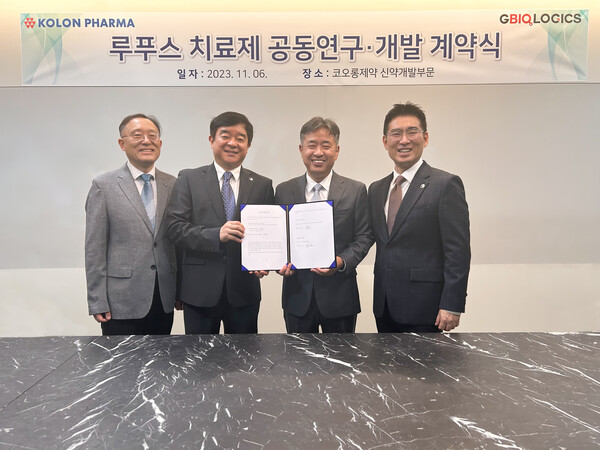 Kolon Pharma co-CEO Kim Sun-jin (second from left) and GBiologics CEO David Song (to Kim's right) hold up the co-development agreement at Kolon Pharma headquarters in Gwacheon, Gyeonggi Province, on Monday.