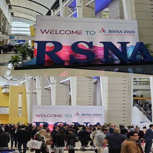 Exhibitors and visitors are waiting to take a picture in front of the RSNA 2023 sign at the McCormick Place Convention Center in Chicago, Ill., on Sunday. While the conference provided both in-person and virtual participation, it was packed with participants attending the event in person.