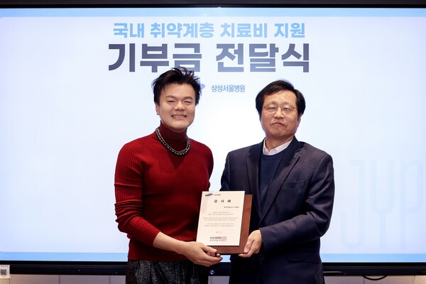 JYP Ent. former head Park Jin-young (left) and SMC's Cancer Center Director Professor Lee Woo-yong pose for a photo commemorating Park’s donation to the hospital at JYP Ent. headquarters in Gangdong-gu, Seoul, Tuesday. (credit: SMC)