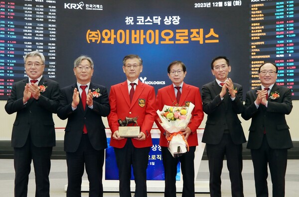 Y-Biologics’s Co-CEOs, Park Young-woo (third from left) and Jang Woo-ick (to Park’s right), pose with stock market officials during the ceremony to celebrate their company’s listing on the Kosdaq market at the Korea Exchange  in Seoul on Tuesday.