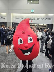 The American Society of Hematology's official mascot Red waves his hands to participants during the conference.