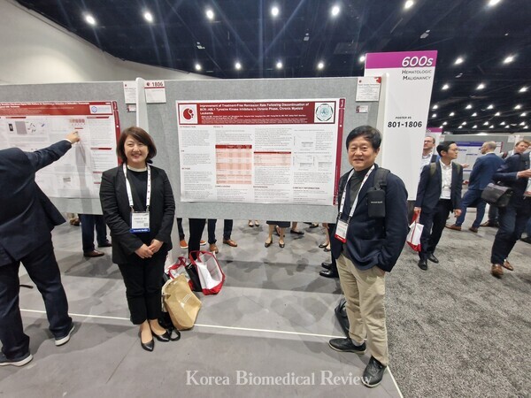 Professor Lee Se-won (left) and Professor Kim Dong-wook pose in front of the poster study, which showed promising results for TFR after long-term Tyrosine Kinase Inhibitor (TKI) therapy indicating the potential to discontinue medication under close monitoring, during the ASH 2023 Conference held in San Diego, Calif., on Saturday.