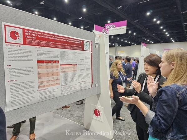 Professor Lee (left) explains her team's study to a participant  during the ASH 2023 Conference held in San Diego, Calif., on Saturday.