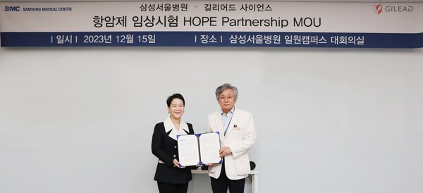 Gilead Sciences Korea General Manager Choi Jae-yeon (left) and SMC Research Vice President Lee Kyu-sung hold up the same MoU at SMC in Gangnam-gu, Seoul, on Friday.