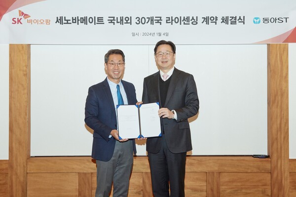 SK biopharmaceuticals CEO Lee Dong-hoon (left) and Dong-A ST CEO Kim Min-young hold up their license agreement at SK Seorin Building in Jongno-gu, Seoul, on Thursday.