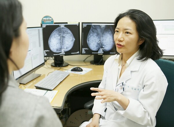 Professor Kim Hee-jeong of the Department of Breast Surgery at Asan Medical Center in Seoul treats a patient. (Courtesy of Asan Medical Center)