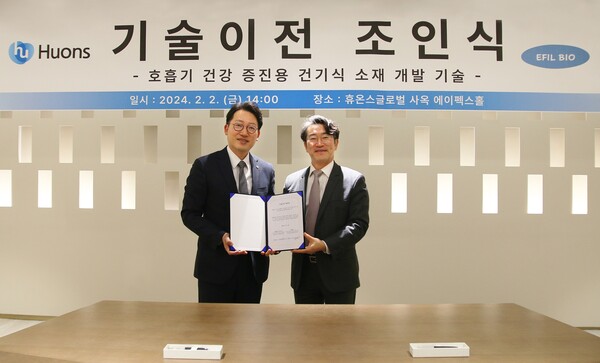 Huons CEO Yoon Sang-bae (left) and EFIL BioScience CEO Kim Kong-sik hold up the licensing agreement at Huons headquarters in Pangyo, Gyeonggi Province, last Friday. (credit: Huons)