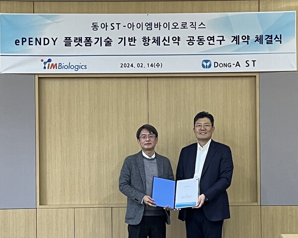 IMBiologics CEO Ha Gyong-sik (left) and Dong-A ST R&D President Park Jae-hong hold up the cooperation agreement at Dong-A ST headquarters in Dongdaemun-gu, Seoul, Wednesday.