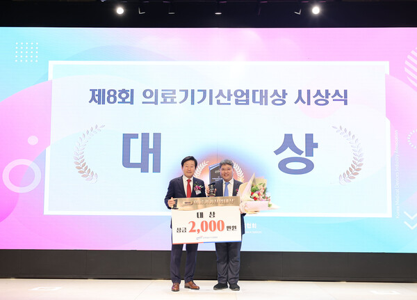 Professor Kuh Sung-uk (right) from Yonsei University's College of Medicine poses for a photo after receiving the grand prize at the 8th Medical Device Industry Awards held at Eliena Hotel in Gangnam-gu, Seoul, Tuesday.