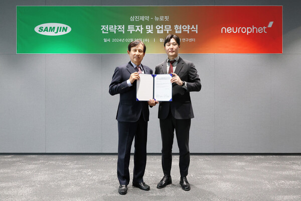 Samjin CEO Choi Yong-ju (left) and Neurophet CEO Been Jun-kil hold up the investment agreement at Samjin R&D Center in Gangseo-gu, Seoul, last Wednesday.