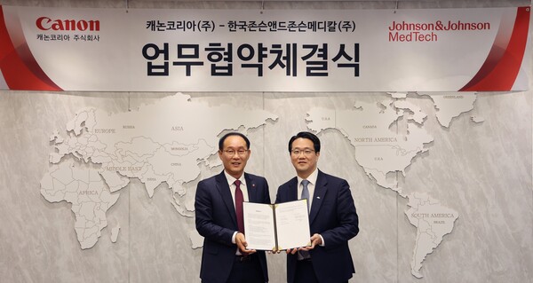 Canon Korea CEO Park Joung-woo (left) and Johnson & Johnson MedTech Korea CEO Oh Jin-yong hold up their agreement at a signing ceremony in Seoul in December 2023.